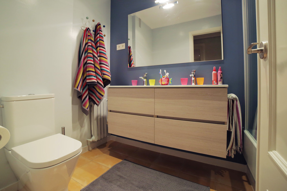 Exempel på ett mellanstort modernt badrum för barn, med möbel-liknande, skåp i ljust trä, ett platsbyggt badkar, blå väggar, klinkergolv i keramik, bänkskiva i akrylsten och gult golv