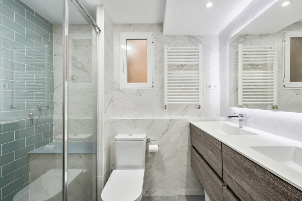 Mittelgroßes Modernes Badezimmer En Suite mit verzierten Schränken, weißen Schränken, Urinal, grauen Fliesen, weißer Wandfarbe, weißer Waschtischplatte, WC-Raum und Doppelwaschbecken in Madrid