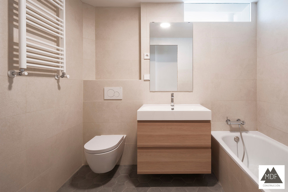 Exemple d'une salle de bain principale tendance en bois clair de taille moyenne avec un placard en trompe-l'oeil, une baignoire en alcôve, WC suspendus, un carrelage beige, des carreaux de céramique, un mur beige, un sol en carrelage de céramique, un lavabo intégré, un plan de toilette en surface solide, un sol gris et un plan de toilette blanc.
