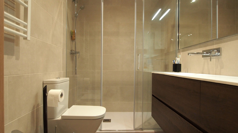 Idéer för små funkis en-suite badrum, med släta luckor, bruna skåp, en dusch i en alkov, en vägghängd toalettstol, beige kakel, keramikplattor, beige väggar, klinkergolv i keramik, ett integrerad handfat, bänkskiva i akrylsten, grått golv och dusch med skjutdörr