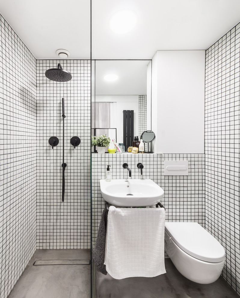 Idéer för ett litet modernt badrum med dusch, med en kantlös dusch, en vägghängd toalettstol, vita väggar, betonggolv, ett väggmonterat handfat och grått golv