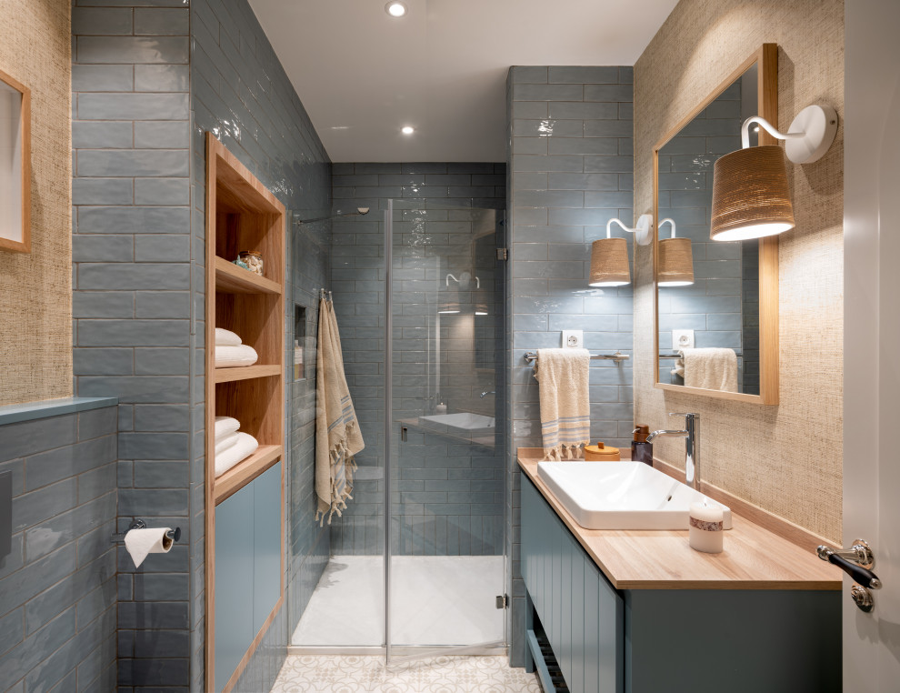Exempel på ett mellanstort klassiskt brun brunt badrum med dusch, med luckor med glaspanel, vita skåp, en kantlös dusch, en vägghängd toalettstol, blå kakel, keramikplattor, blå väggar, klinkergolv i keramik, ett fristående handfat, laminatbänkskiva, dusch med gångjärnsdörr och beiget golv