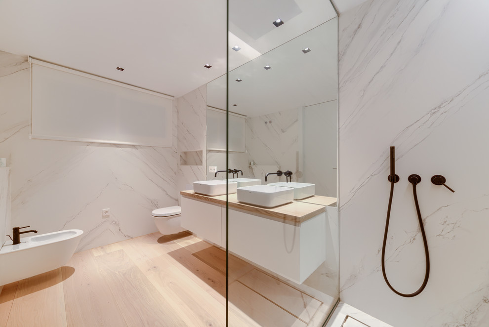 Idéer för ett mellanstort modernt en-suite badrum, med släta luckor, vita skåp, en öppen dusch, vit kakel, marmorkakel, vita väggar, mellanmörkt trägolv, ett fristående handfat, träbänkskiva och brunt golv