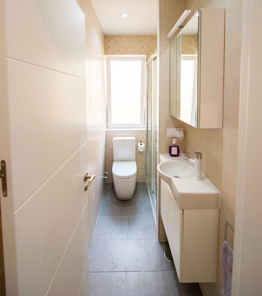 Стильный дизайн: маленькая ванная комната в стиле модернизм с фасадами островного типа, бежевыми фасадами, душевой комнатой, писсуаром, бежевой плиткой, керамической плиткой, бежевыми стенами, полом из керамической плитки, душевой кабиной, настольной раковиной, мраморной столешницей, коричневым полом, душем с раздвижными дверями и бежевой столешницей для на участке и в саду - последний тренд