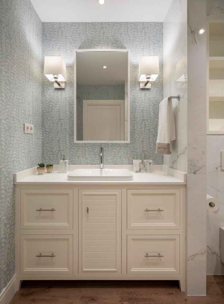 Idéer för ett stort klassiskt vit en-suite badrum, med möbel-liknande, vita skåp, en kantlös dusch, en vägghängd toalettstol, vit kakel, porslinskakel, blå väggar, laminatgolv, ett undermonterad handfat, träbänkskiva, brunt golv och dusch med skjutdörr