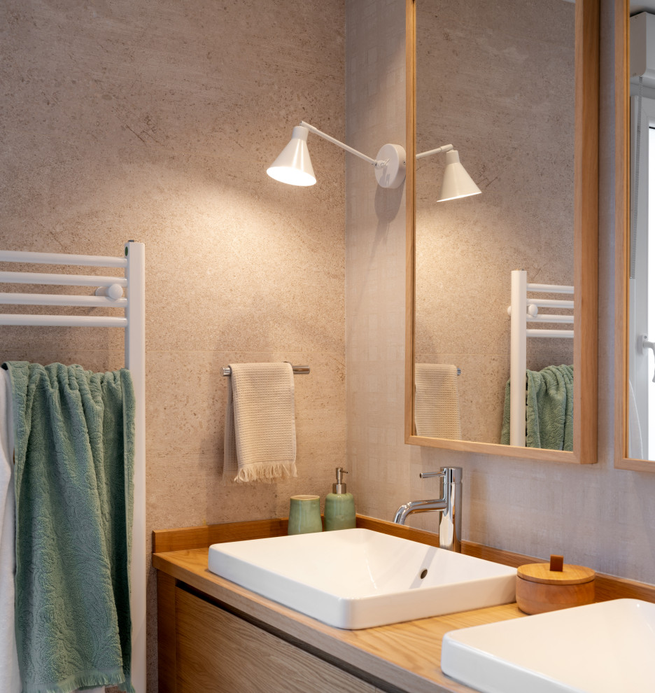 Пример оригинального дизайна: главная ванная комната среднего размера в стиле неоклассика (современная классика) с плоскими фасадами, белыми фасадами, инсталляцией, бежевой плиткой, бежевыми стенами, полом из ламината, настольной раковиной, столешницей из ламината, бежевым полом, коричневой столешницей, тумбой под две раковины, встроенной тумбой и обоями на стенах