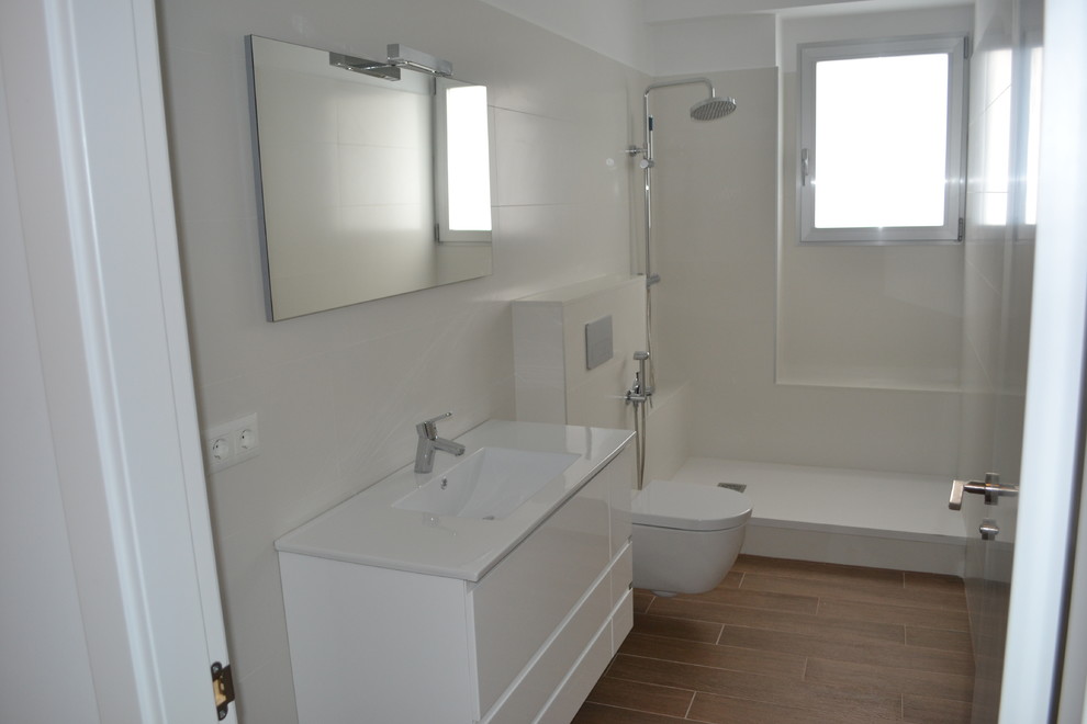 На фото: ванная комната среднего размера в современном стиле с плоскими фасадами, белыми фасадами, открытым душем, инсталляцией, душевой кабиной и монолитной раковиной