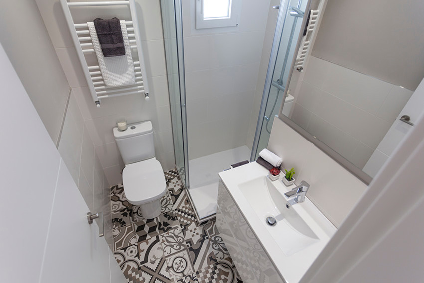 Modernes Badezimmer mit Nasszelle, grauer Wandfarbe, Keramikboden, Wandwaschbecken, buntem Boden und Schiebetür-Duschabtrennung in Madrid