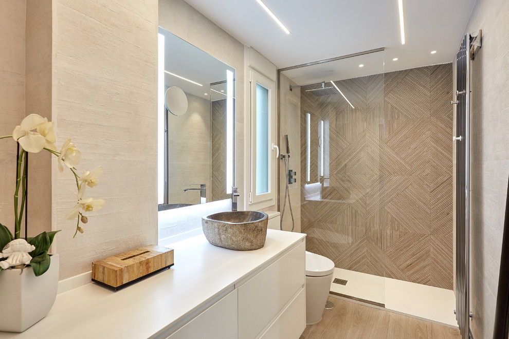 На фото: ванная комната в современном стиле с плоскими фасадами, белыми фасадами, душем в нише, бежевой плиткой, белыми стенами, душевой кабиной, настольной раковиной, коричневым полом, открытым душем и белой столешницей с