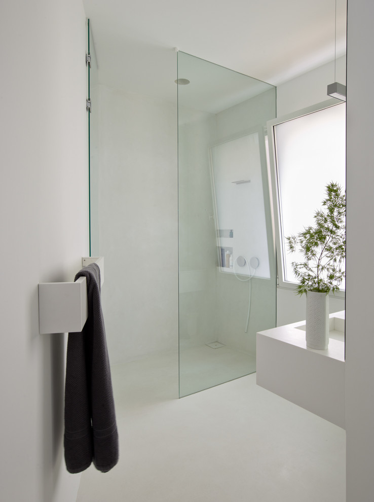Ejemplo de cuarto de baño moderno con ducha a ras de suelo, paredes blancas, aseo y ducha y lavabo suspendido