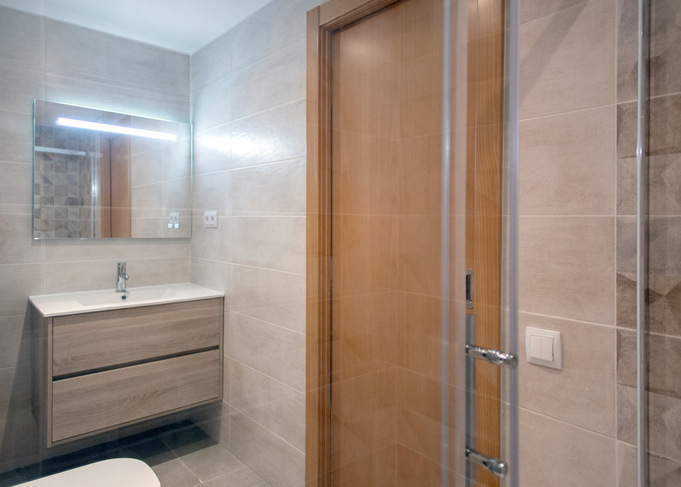 Inredning av ett modernt mellanstort vit vitt en-suite badrum, med skåp i ljust trä, en kantlös dusch, en toalettstol med hel cisternkåpa, beige kakel, beiget golv och dusch med skjutdörr