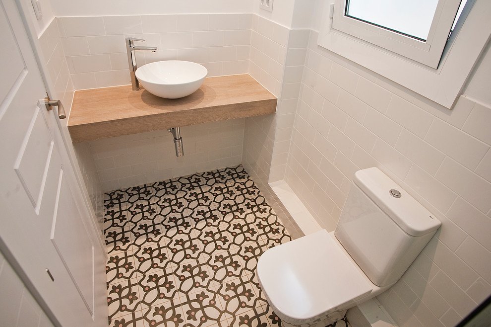 Inspiration for a medium sized classic ensuite bathroom in Barcelona with an alcove shower, a one-piece toilet, white tiles, metro tiles, white walls, mosaic tile flooring, a trough sink and wooden worktops.