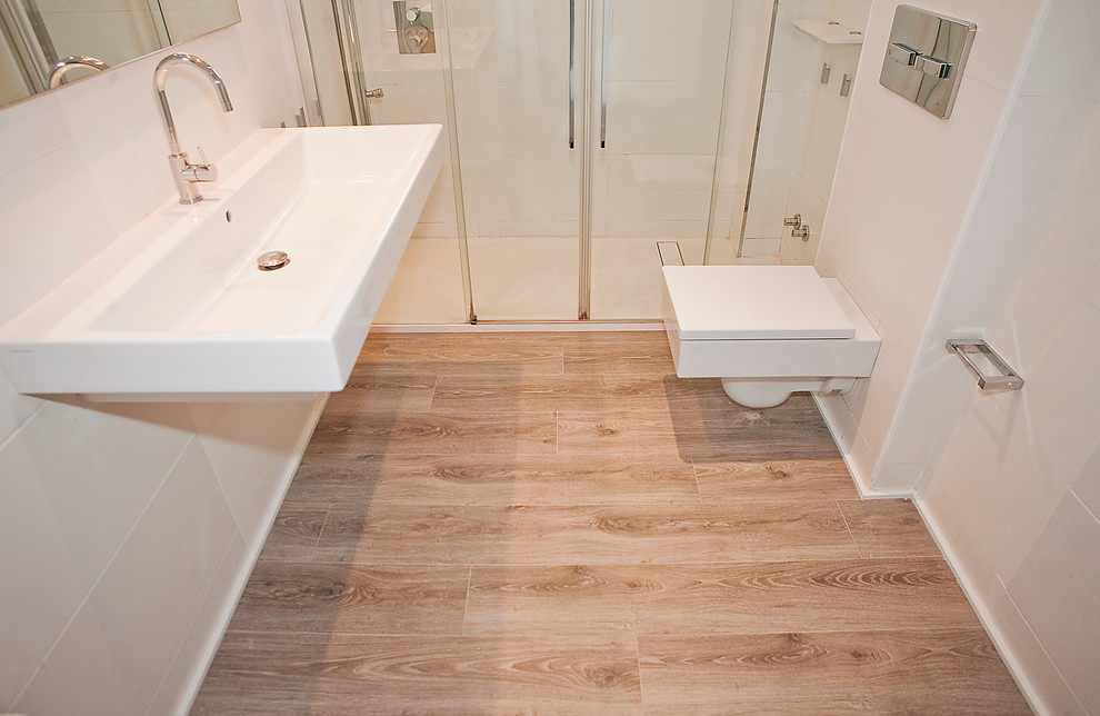 Photo of a medium sized scandinavian ensuite bathroom in Barcelona with white cabinets, an alcove shower, a one-piece toilet, white tiles, white walls, dark hardwood flooring and a trough sink.