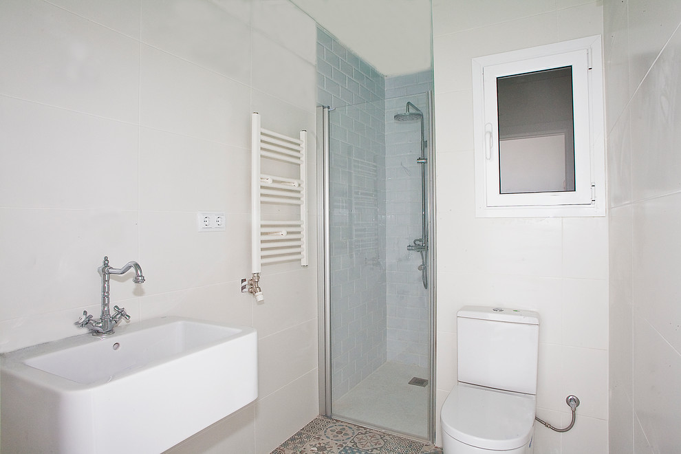 Exempel på ett mellanstort medelhavsstil en-suite badrum, med en dusch i en alkov, en toalettstol med hel cisternkåpa, flerfärgad kakel, porslinskakel, vita väggar, klinkergolv i terrakotta, ett avlångt handfat och marmorbänkskiva