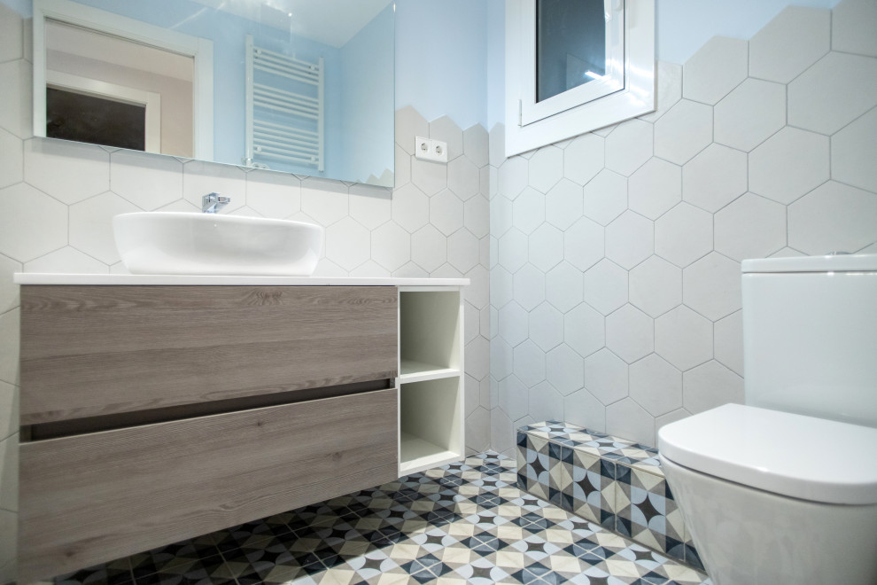 Bild på ett mellanstort funkis vit vitt en-suite badrum, med skåp i mellenmörkt trä, en kantlös dusch, en toalettstol med hel cisternkåpa, beige kakel, keramikplattor, blå väggar, klinkergolv i keramik, beiget golv och dusch med skjutdörr