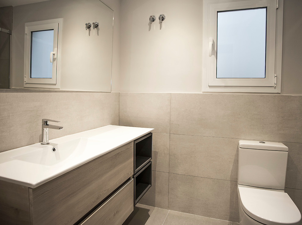 На фото: главная ванная комната в средиземноморском стиле с фасадами цвета дерева среднего тона, душем без бортиков, унитазом-моноблоком, бежевой плиткой, бежевыми стенами, бежевым полом и душем с раздвижными дверями