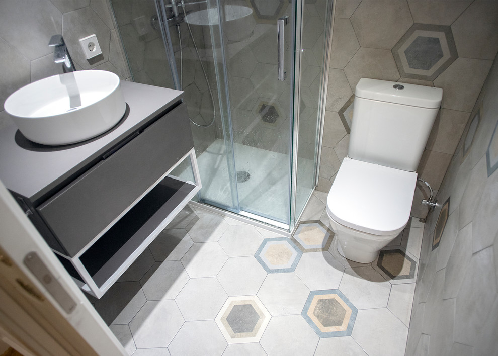 Cette image montre une salle de bain principale design de taille moyenne avec une douche à l'italienne, WC à poser, un carrelage gris, une cabine de douche à porte coulissante et un plan de toilette blanc.