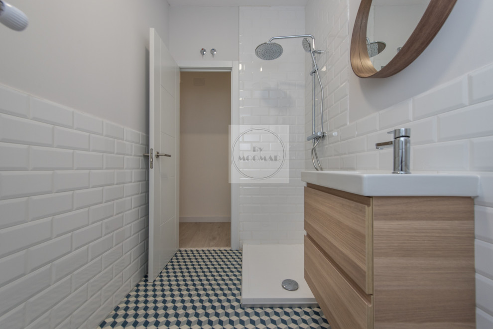 Exempel på ett mellanstort modernt vit vitt en-suite badrum, med möbel-liknande, vita skåp, våtrum, en vägghängd toalettstol, vit kakel, keramikplattor, vita väggar, kaklad bänkskiva och blått golv