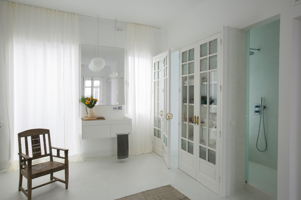 Стильный дизайн: главная ванная комната в современном стиле с плоскими фасадами, белыми фасадами, душем в нише, белыми стенами, подвесной раковиной, белым полом и открытым душем - последний тренд