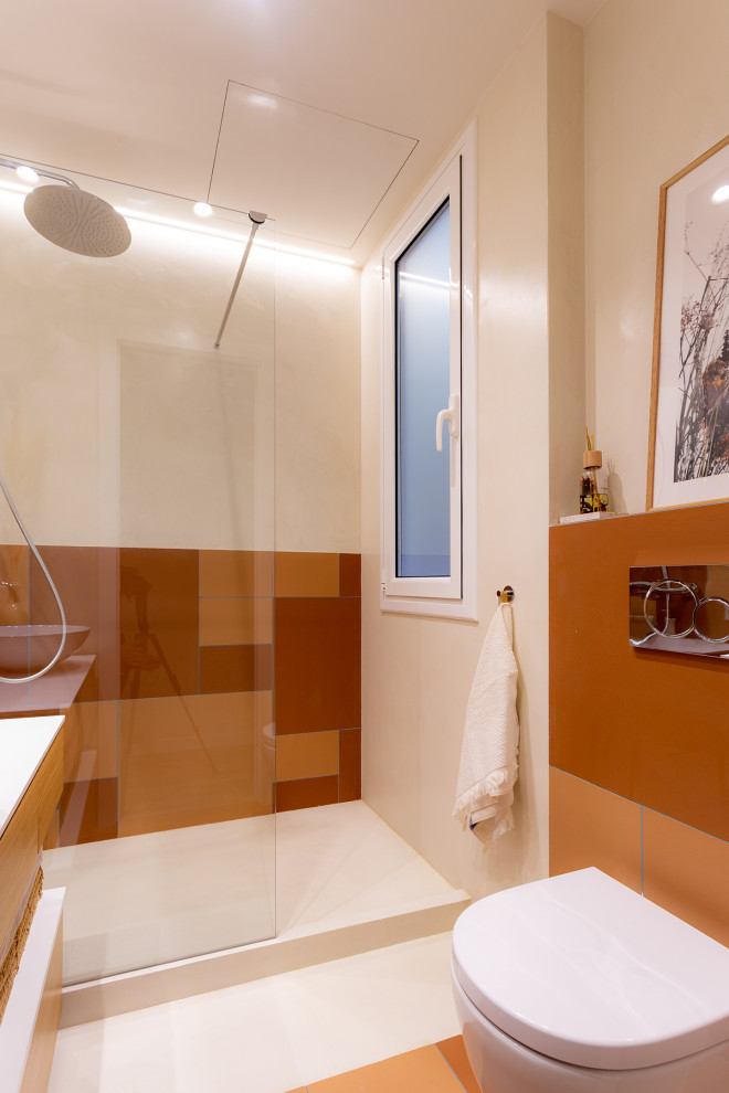 Cette photo montre une petite salle de bain principale bord de mer avec des portes de placard blanches, une douche à l'italienne, WC suspendus, un carrelage orange, un mur multicolore, une vasque, un sol multicolore, aucune cabine, un plan de toilette blanc, meuble simple vasque et meuble-lavabo suspendu.