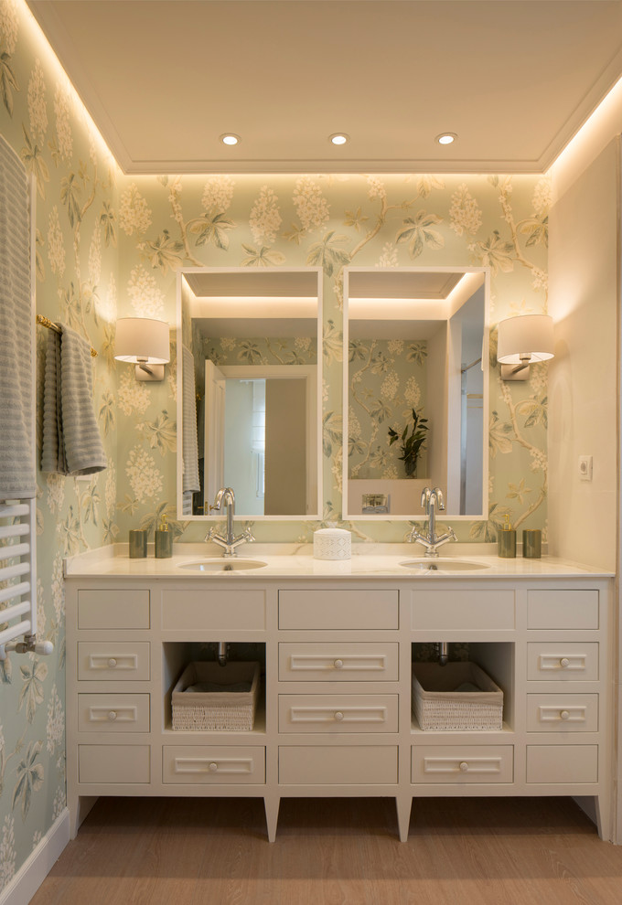 Klassisk inredning av ett stort en-suite badrum, med luckor med upphöjd panel, vita skåp, en kantlös dusch, en vägghängd toalettstol, beige kakel, keramikplattor, gröna väggar, ett undermonterad handfat, marmorbänkskiva, dusch med skjutdörr och laminatgolv