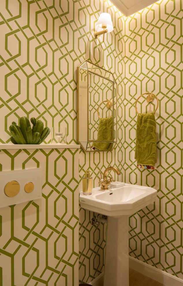 Diseño de aseo clásico renovado de tamaño medio con sanitario de pared, baldosas y/o azulejos verdes, paredes verdes, lavabo con pedestal y suelo laminado