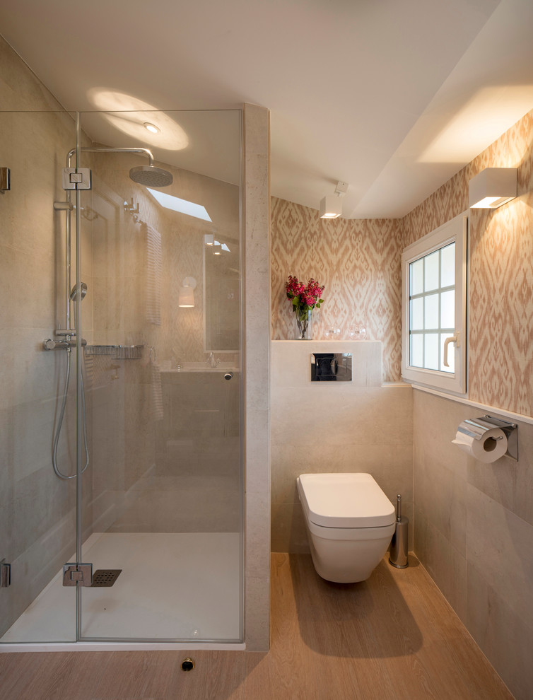 This is an example of a large modern family bathroom in Bilbao with raised-panel cabinets, grey cabinets, an alcove shower, a wall mounted toilet, beige tiles, ceramic tiles, beige walls, laminate floors, a submerged sink, engineered stone worktops and a hinged door.