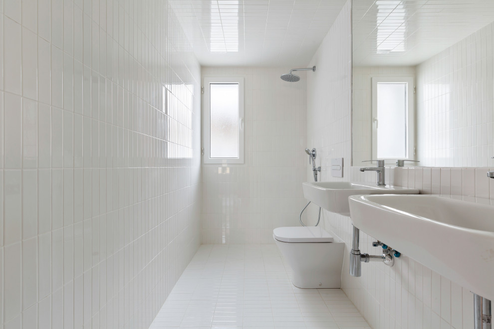 Design ideas for a medium sized modern ensuite bathroom with white cabinets, a built-in shower, white tiles, ceramic tiles, ceramic flooring, a built-in sink, engineered stone worktops, white floors and grey worktops.
