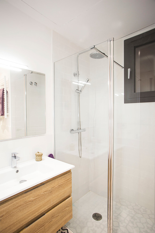 Réalisation d'une salle de bain nordique en bois brun de taille moyenne avec WC à poser, un carrelage blanc et un mur blanc.