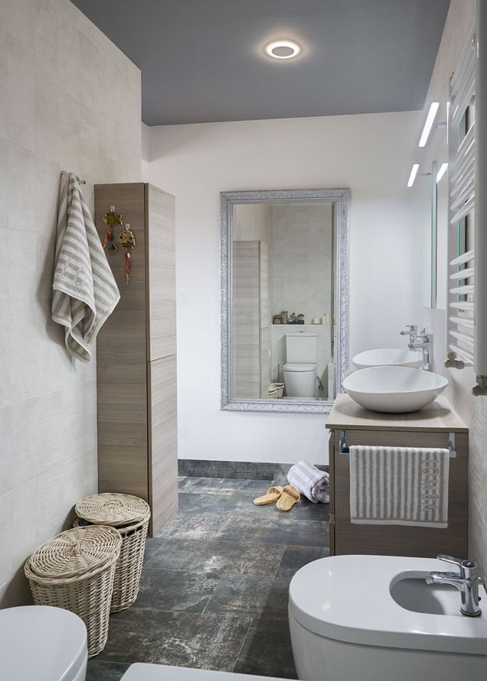 Exemple d'une salle d'eau grise et blanche tendance en bois clair de taille moyenne avec meuble double vasque, WC suspendus, un carrelage beige, un mur blanc, une vasque, un plan de toilette en bois, un sol gris, un plan de toilette beige et meuble-lavabo encastré.