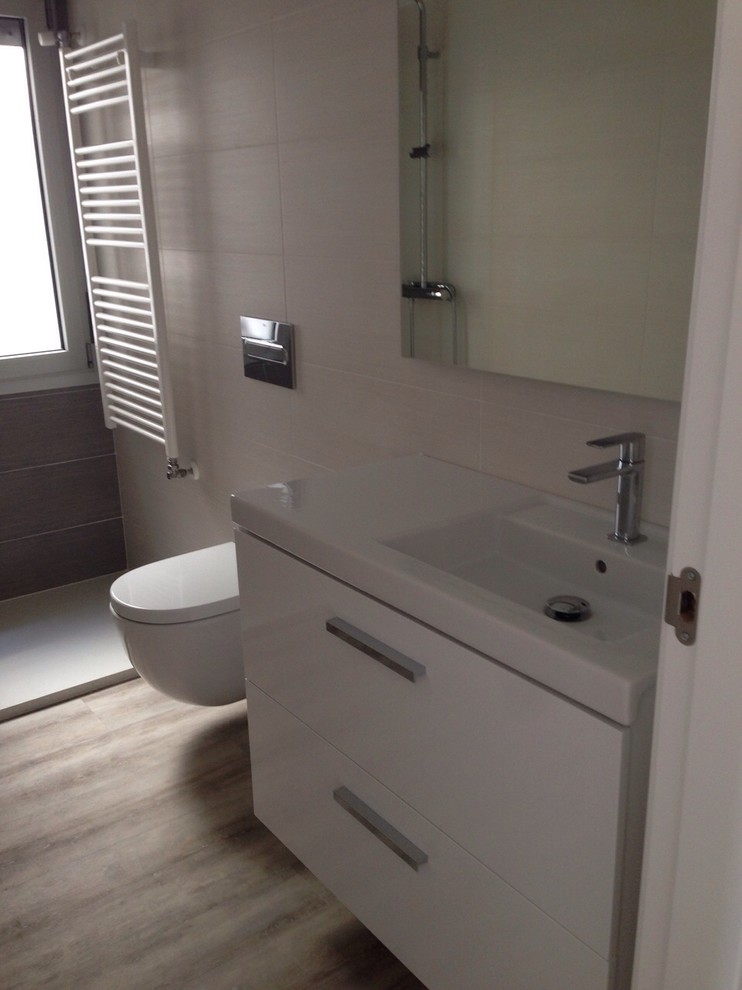 Esempio di una piccola stanza da bagno con doccia minimal con ante lisce, ante bianche, doccia a filo pavimento, WC monopezzo, pareti beige e lavabo integrato