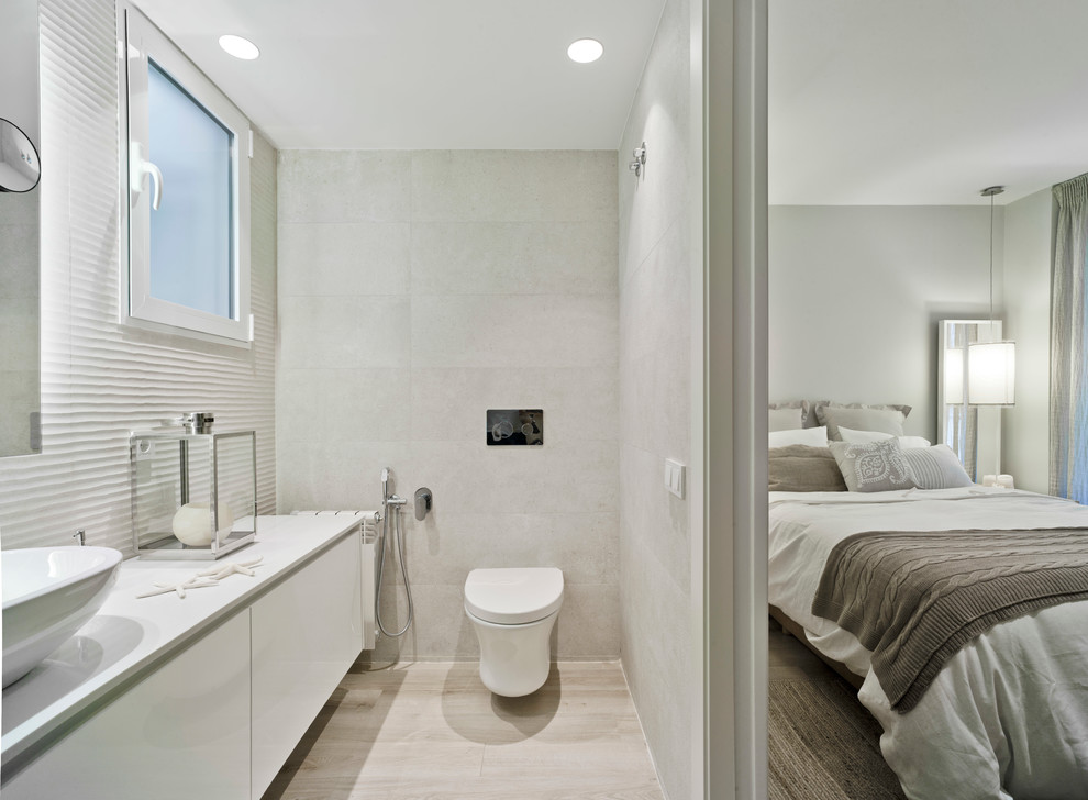 Ejemplo de cuarto de baño principal contemporáneo de tamaño medio con armarios con paneles lisos, puertas de armario blancas, sanitario de pared y lavabo sobreencimera