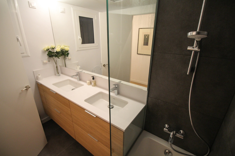 Idee per una piccola stanza da bagno con doccia scandinava con ante lisce, ante in legno scuro, vasca ad alcova, vasca/doccia e lavabo integrato