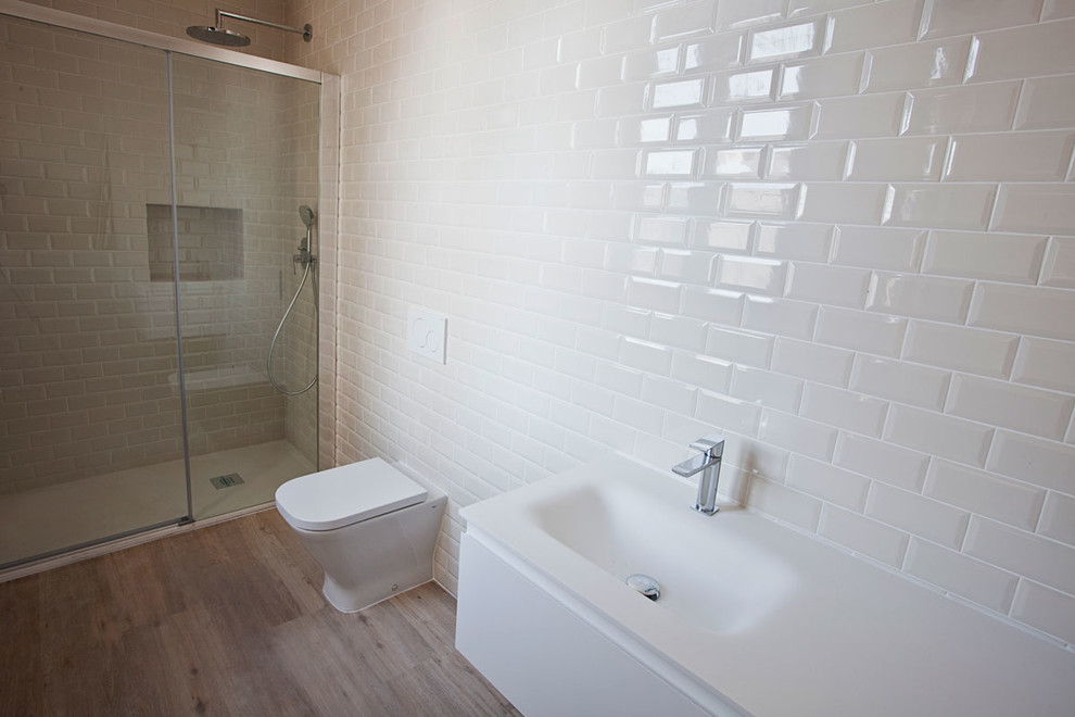 На фото: ванная комната среднего размера в стиле лофт с плоскими фасадами, белыми фасадами, инсталляцией, бежевой плиткой, керамической плиткой, бежевыми стенами, светлым паркетным полом и накладной раковиной