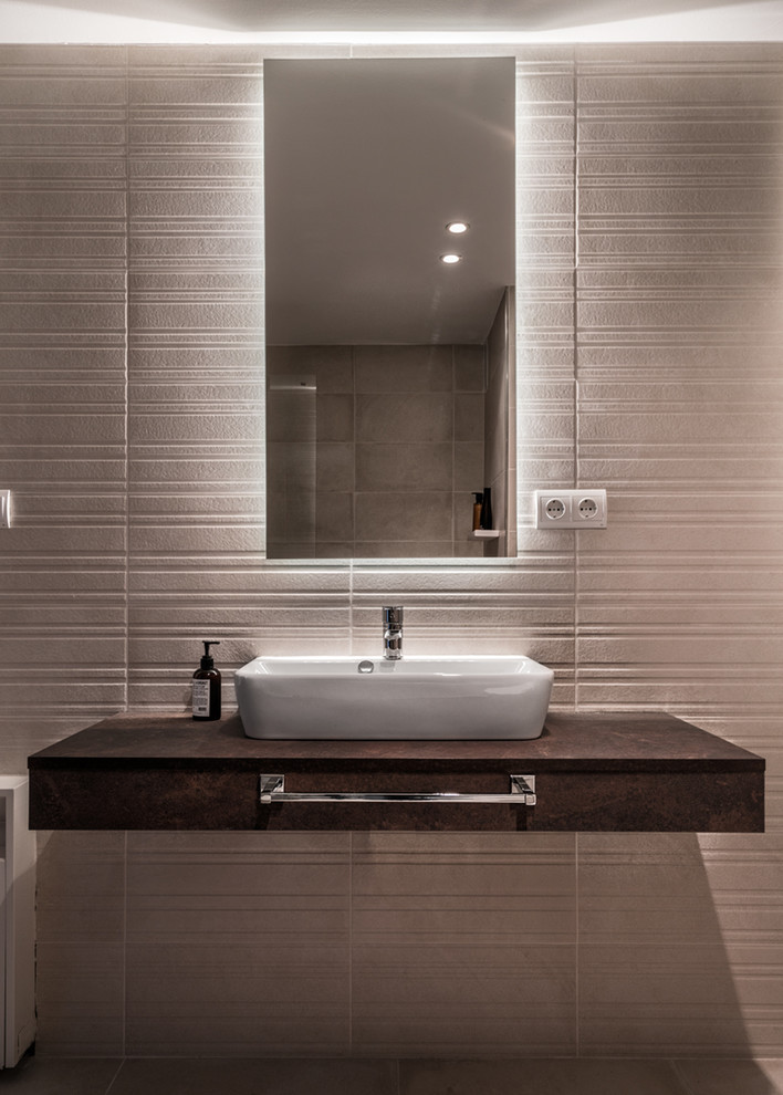 Mid-sized trendy 3/4 beige tile and ceramic tile ceramic tile and brown floor alcove bathtub photo in Other with open cabinets, distressed cabinets, a one-piece toilet, beige walls, a vessel sink, laminate countertops and a hinged shower door