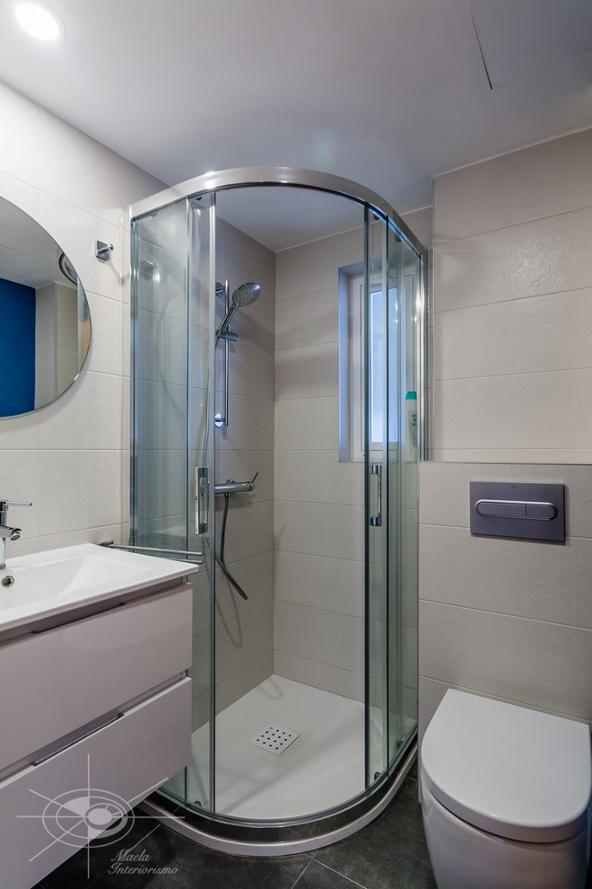 Cette photo montre une petite salle d'eau tendance avec des portes de placard blanches, une douche d'angle, WC suspendus, un carrelage blanc, des carreaux de céramique, un mur bleu, un sol en carrelage de porcelaine, un lavabo suspendu, un sol gris, une cabine de douche à porte coulissante et un plan de toilette blanc.