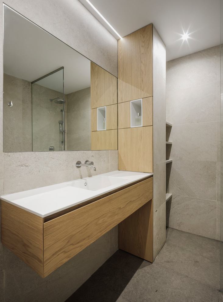 Пример оригинального дизайна: ванная комната в стиле модернизм с столешницей из искусственного кварца, белой столешницей, фасадами цвета дерева среднего тона, серой плиткой, керамогранитной плиткой, плоскими фасадами, угловым душем, серыми стенами, бетонным полом, душевой кабиной, монолитной раковиной, серым полом и открытым душем