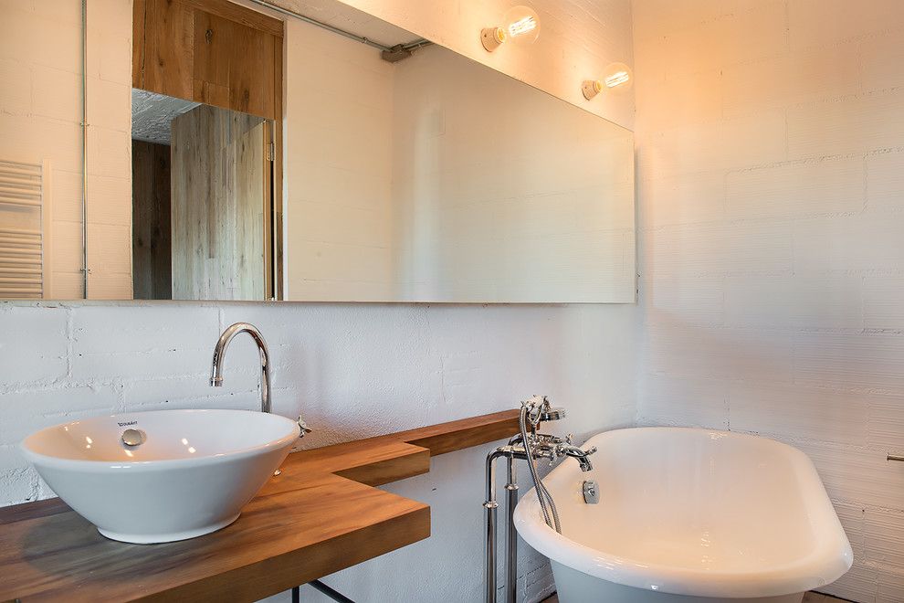 Inredning av ett modernt litet en-suite badrum, med ett fristående badkar, en dusch/badkar-kombination, vita väggar, ett fristående handfat och träbänkskiva
