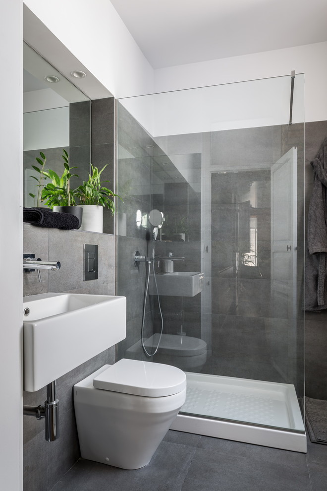 Immagine di una stanza da bagno con doccia minimal di medie dimensioni con doccia ad angolo, WC monopezzo, pareti grigie, pavimento con piastrelle in ceramica e lavabo sospeso