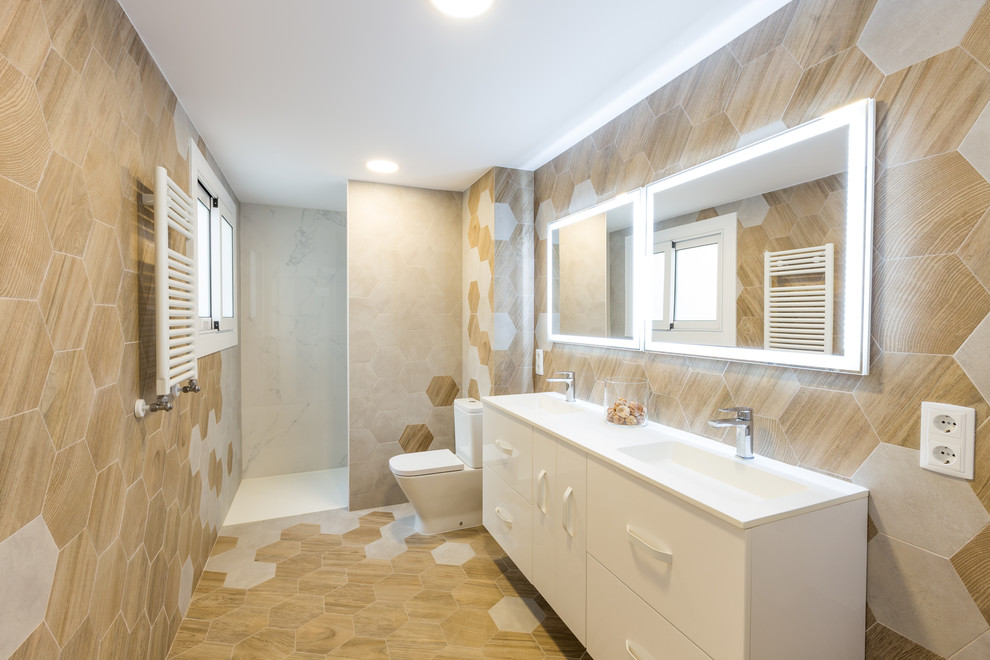 Bild på ett funkis badrum, med släta luckor, vita skåp, beige kakel, beige väggar, ett integrerad handfat och beiget golv