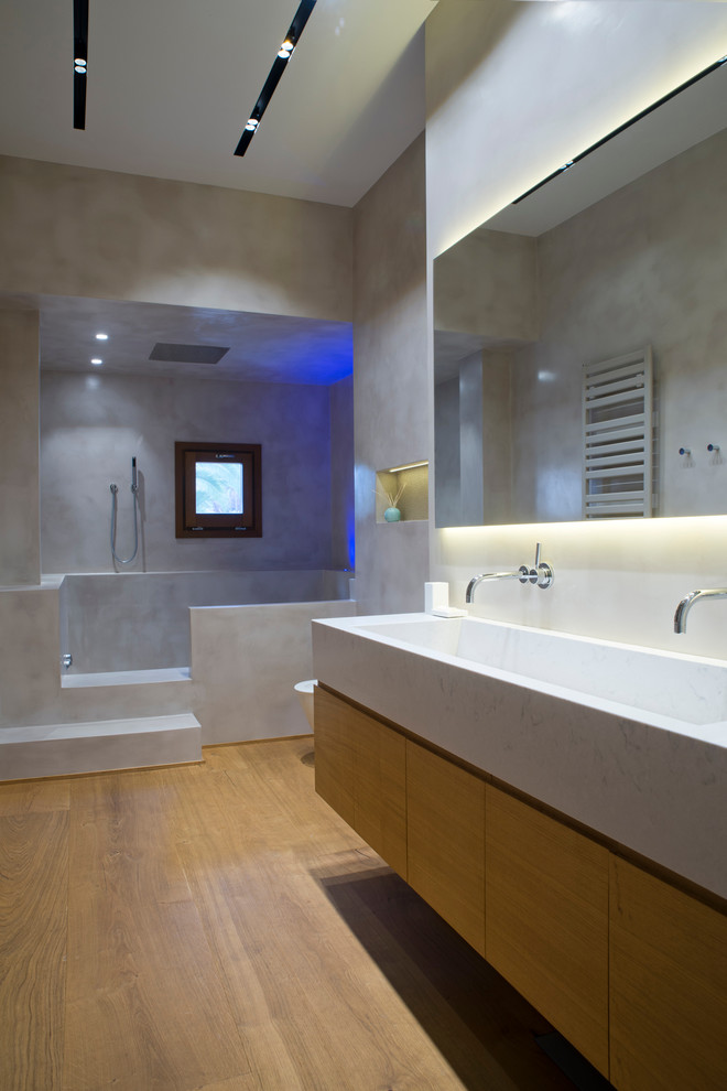 Cette photo montre une douche en alcôve principale chic en bois brun de taille moyenne avec un placard en trompe-l'oeil, WC à poser, un mur gris, un sol en bois brun et un lavabo intégré.