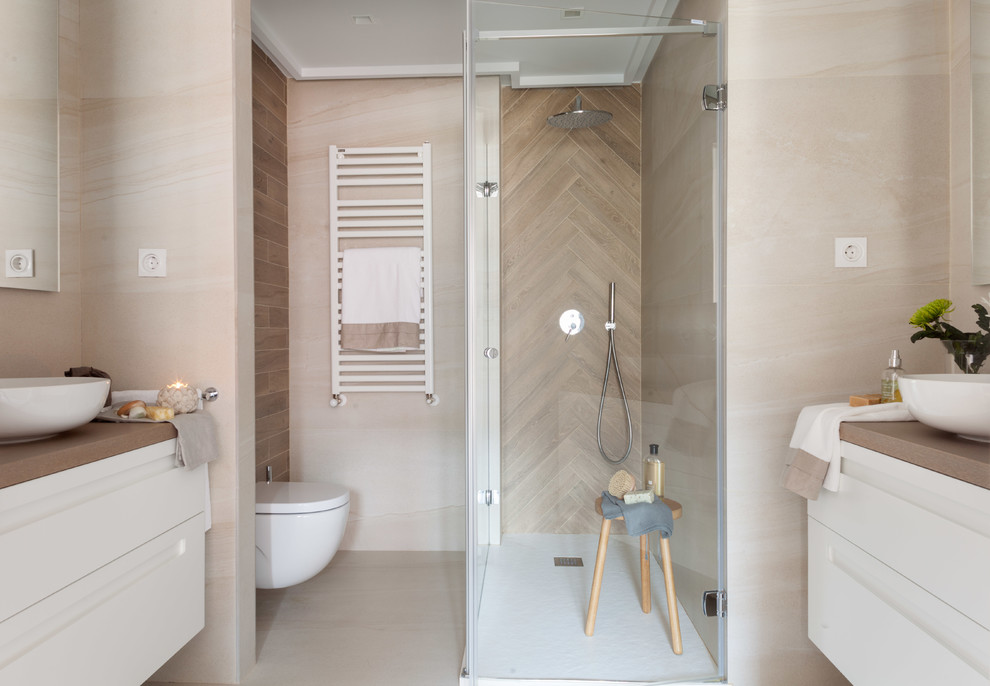 Réalisation d'une salle de bain design avec un placard à porte plane, des portes de placard blanches, WC suspendus, un carrelage beige, une vasque, un plan de toilette en bois, un sol beige, une cabine de douche à porte battante et un plan de toilette marron.