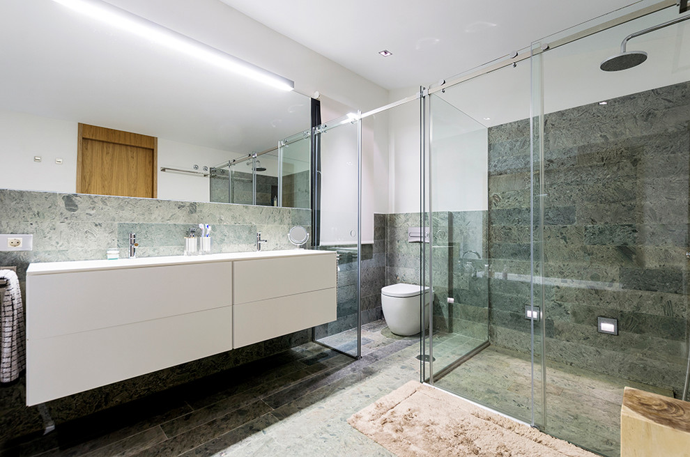 На фото: большая ванная комната в современном стиле с плоскими фасадами, белыми фасадами, угловым душем, унитазом-моноблоком, белыми стенами, душевой кабиной и врезной раковиной