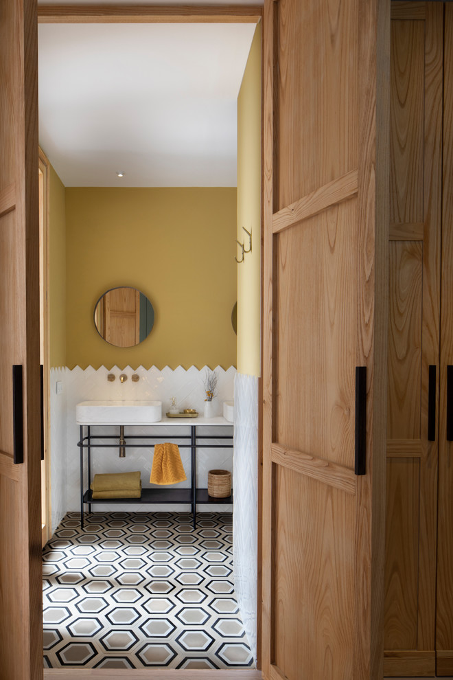 Cette image montre une salle d'eau vintage avec un placard sans porte, un carrelage blanc et une vasque.