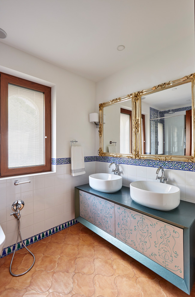 Idéer för medelhavsstil blått badrum, med släta luckor, vit kakel, vita väggar, ett fristående handfat och brunt golv