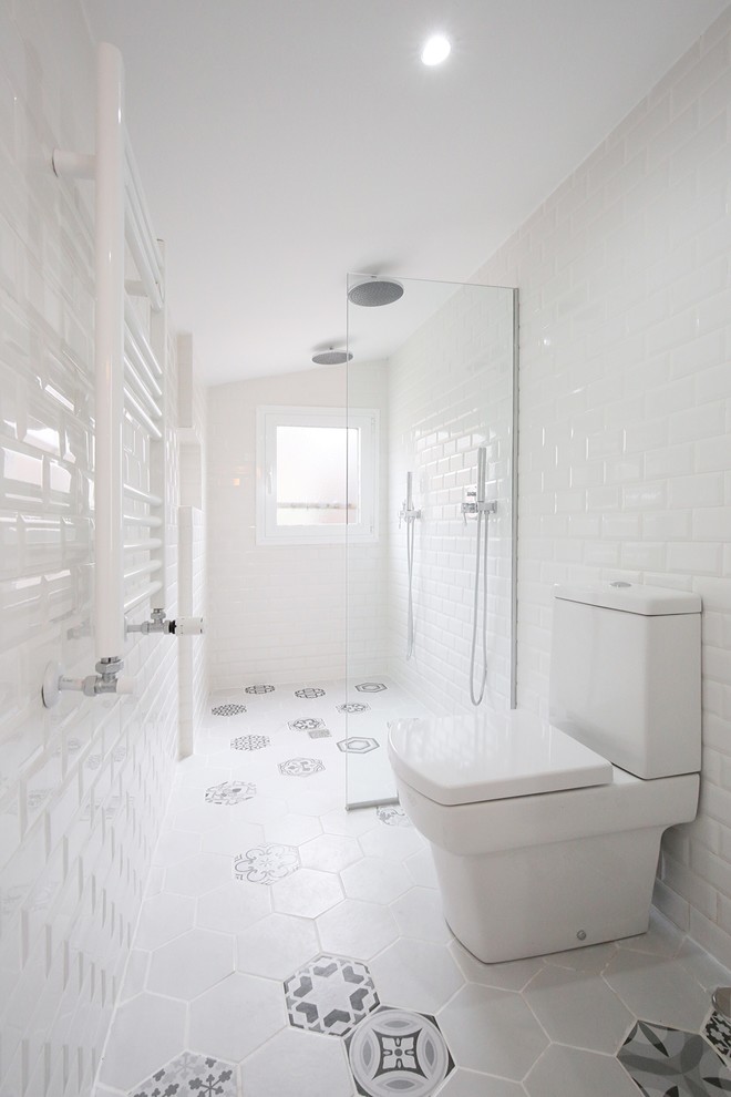 Modelo de cuarto de baño nórdico de tamaño medio con ducha a ras de suelo, sanitario de dos piezas, paredes blancas y aseo y ducha
