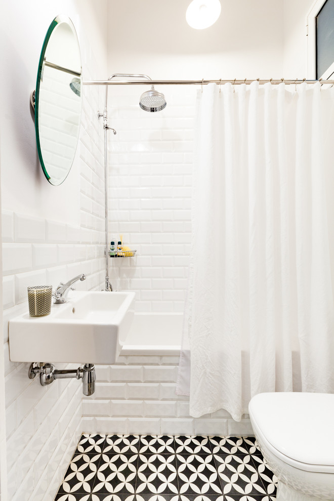 Foto de cuarto de baño escandinavo de tamaño medio con bañera empotrada, combinación de ducha y bañera, sanitario de dos piezas, paredes blancas, suelo de baldosas de cerámica, aseo y ducha y lavabo suspendido