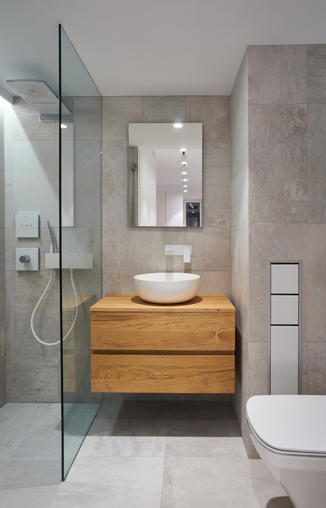 Immagine di una stanza da bagno con doccia contemporanea con ante in legno scuro, doccia a filo pavimento, piastrelle grigie, pareti grigie, lavabo a bacinella, top in legno e ante lisce