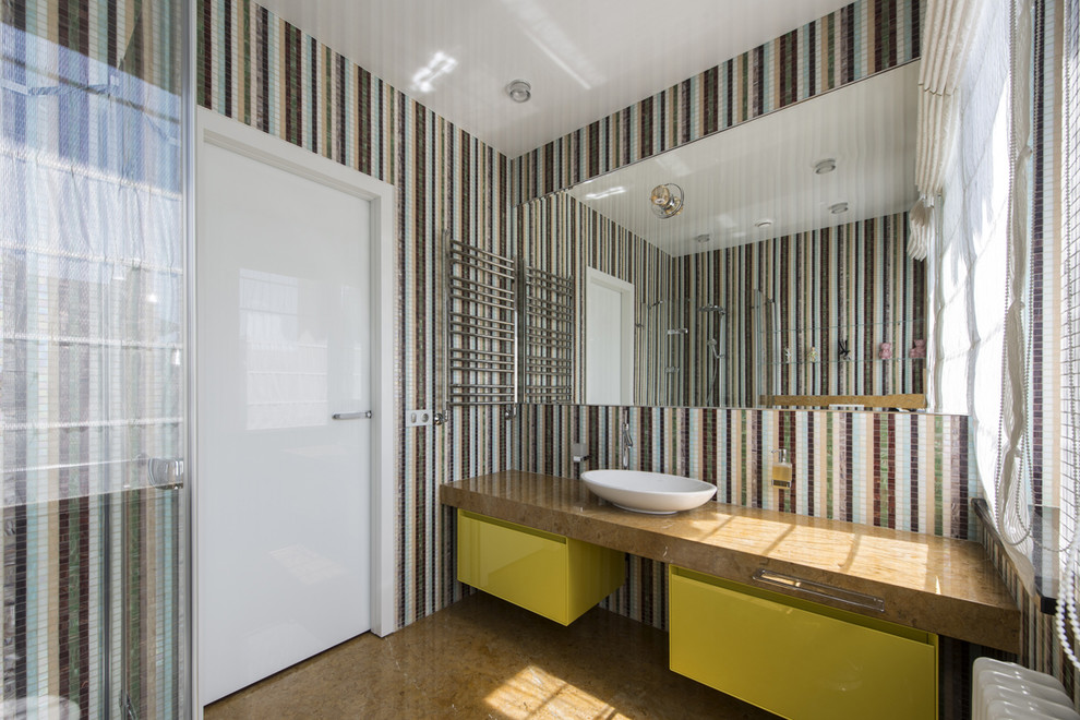 Cette photo montre une salle d'eau tendance avec un placard à porte plane, des portes de placard jaunes, une douche d'angle, un carrelage multicolore, mosaïque et une vasque.