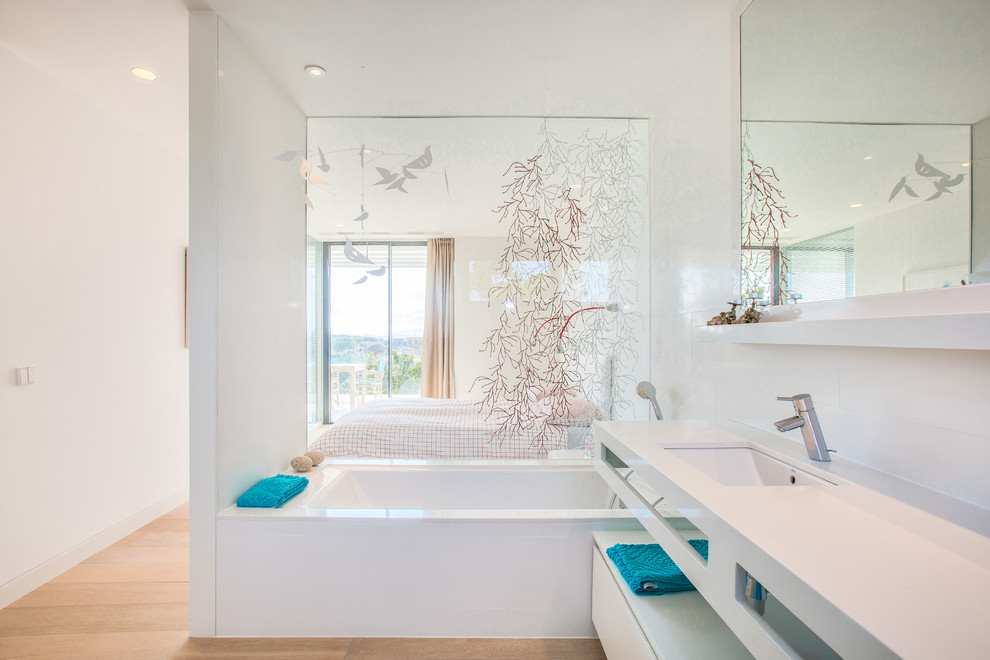 Foto på ett funkis vit en-suite badrum, med möbel-liknande, vita skåp, ett platsbyggt badkar, vita väggar och ett nedsänkt handfat
